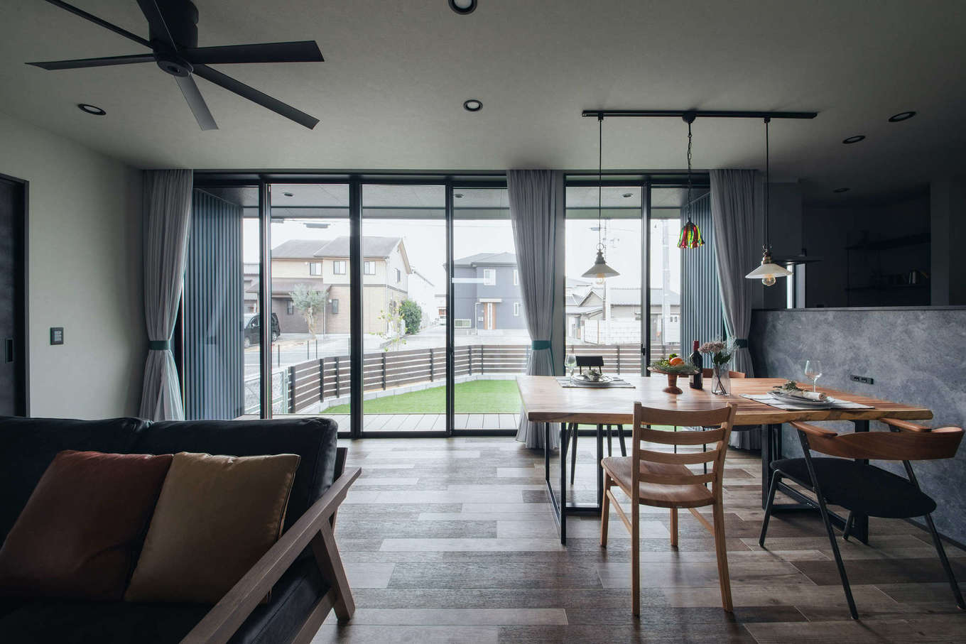 DAITOKU（大得工務店）【夫婦で暮らす、ペット、平屋】天井まで届くハイサッシを採用した大開口リビング。庭、ウッドデッキ、室内がつながり、より開放感が生まれた。インテリアコーディネーターと一緒に選んだ上質なカーテンが暮らしに彩りを与える