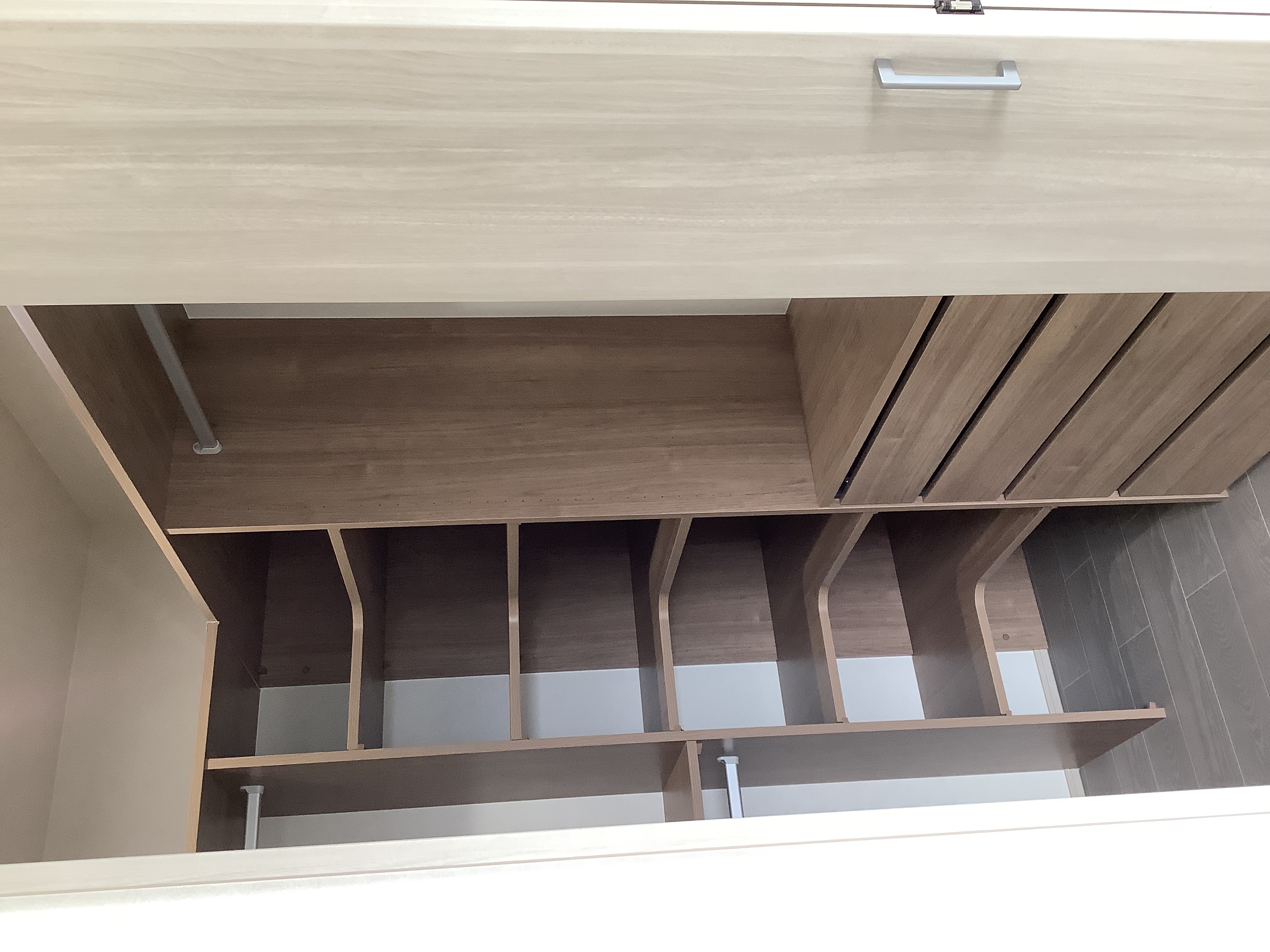 フロート・ハウス｜木目調で統一されたウォークインクローゼット。多様な収納スペースが設けられており、衣類や小物を効率的に整理できる。