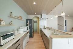 オープンラックやカウンター上の「見せる収納」を活かして、おしゃれにコーディネートしたキッチンで、家事のテンションがアップ。キッチンのサイドにはパントリーを設けてあり、廊下につながっている