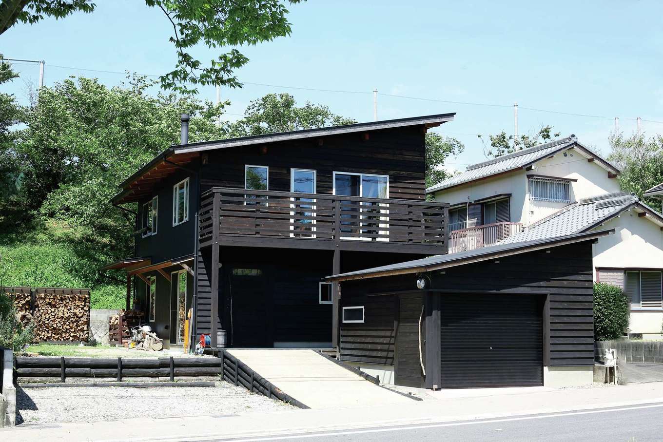 有吉住宅【子育て、趣味、自然素材】「軽井沢の別荘みたい！」と友人から絶賛されるおしゃれな外観。手前はガレージ兼納戸