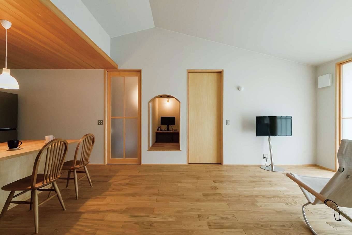 仲田工務店【趣味、間取り、平屋】リビングの勾配天井とキッチンの下がり天井がほどよいバランス。隠れ家のような空間は奥さまが在宅ワークに使用。アーチの縁取りは木を曲げて実現した