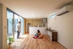 外観の印象とは全く異なる、明るさに包まれたLDK。ハイサッシにはロールスクリーンを設置しているが、外からの視線は届かないので、夜もオープンにして過ごすことが多いそう。リビングの床は無垢のバーチ