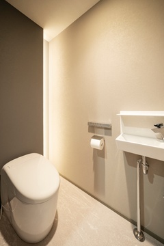 シンプルで機能的なトイレ。控えめなライティングが落ち着いた雰囲気を作り出し、プライベートな時間をより快適に過ごせる。