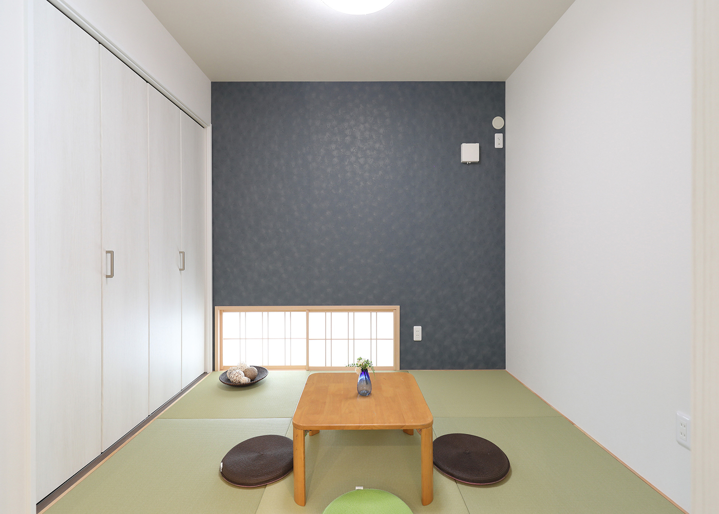 丸昇彦坂建設【デザイン住宅、和風、間取り】小上がりの和室は地窓に障子戸を取り付け、上質な和の空間を演出。壁面にはたっぷり収納できるスペースを。キッチンからでも見守ることができるので、子どもが小さいうちは布団を敷いて寝かせたり、おもちゃ遊びをしたりすることで安心して家事をこなせる