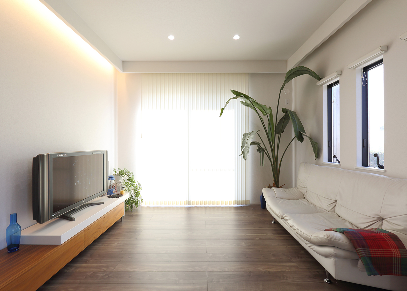 丸昇彦坂建設【デザイン住宅、趣味、インテリア】白のクロスに観葉植物の緑が映えるリビング。垂れ壁で囲われた天井に圧迫感がなく、開放感を演出する