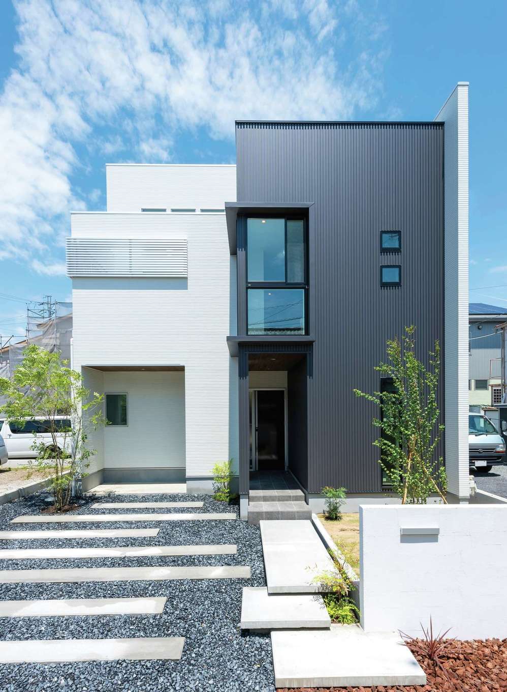 三和建設【デザイン住宅、間取り、スキップフロア】ツートンカラーの外観はシンプルに。一見2階建てだが、建物内は4層の大空間が広がる。玄関脇には自転車や子どもの遊び道具を置ける、屋根付きのサイクルボードも設置
