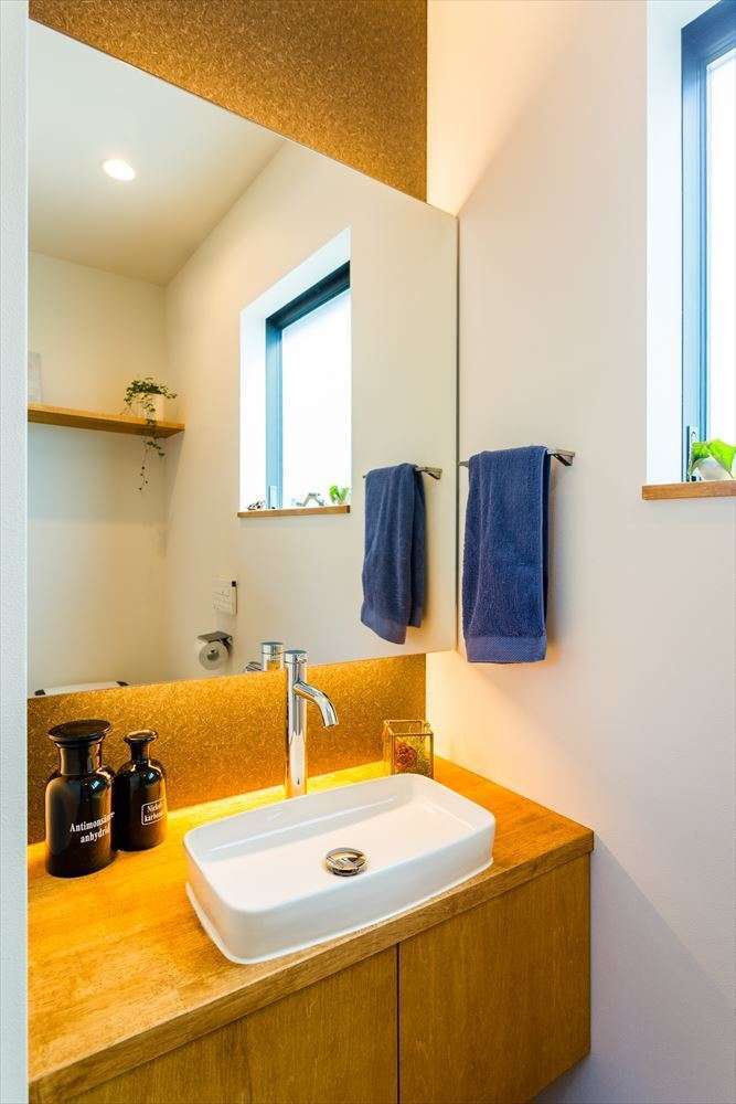 温戸ライフ【自然素材、狭小住宅、間取り】トイレの中とは思えないほどおしゃれに造り込まれた手洗いコーナー。大きな鏡は、座った時に自分の顔が写らない高さに計算されている