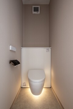 落ち着いたトーンのトイレ空間。フロアライトが柔らかく照らし、リラックスできる雰囲気を演出している
