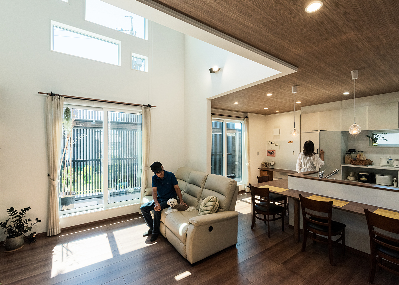 イシカワ【収納力、省エネ、ペット】開放感に満ちた2階のLDK。以前は日当たりが良すぎて暑かったため、1日じゅうレースのカーテンを閉めていたけれど、ルーバーで目隠しと遮熱をしつつ、吹き抜けを設けたことで3階から十分な光を取り込んでいる。窓は高性能のトリプルガラス樹脂サッシ