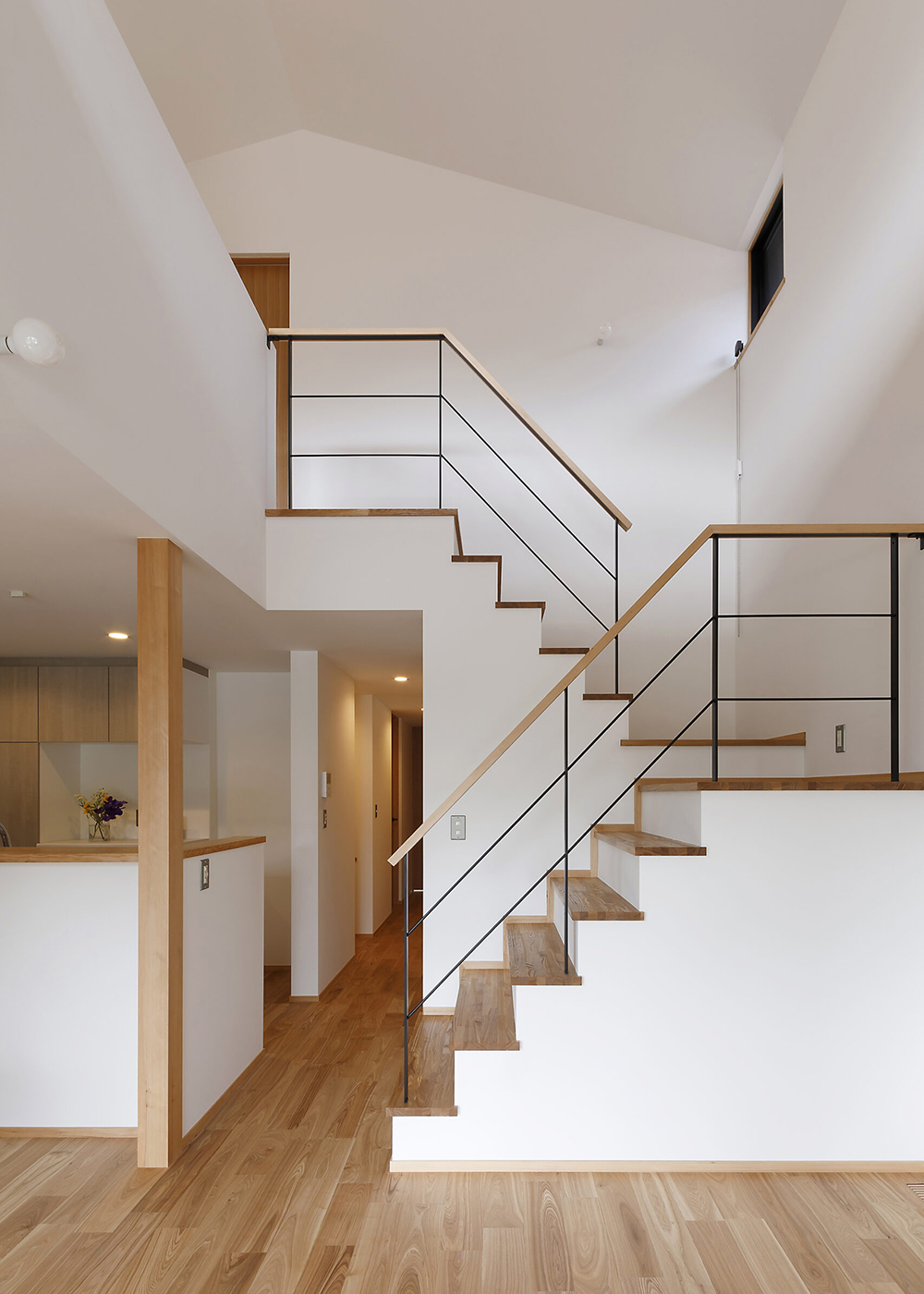 灯建築舎【デザイン住宅、自然素材、省エネ】アイアンと木製手すりを組み合わせた階段をアクセントに、開放感、洗練、ぬくもりが融合する空間に仕上げられた。山型の勾配天井が小さなかわいさを添え、空間の印象をやわらかくしている