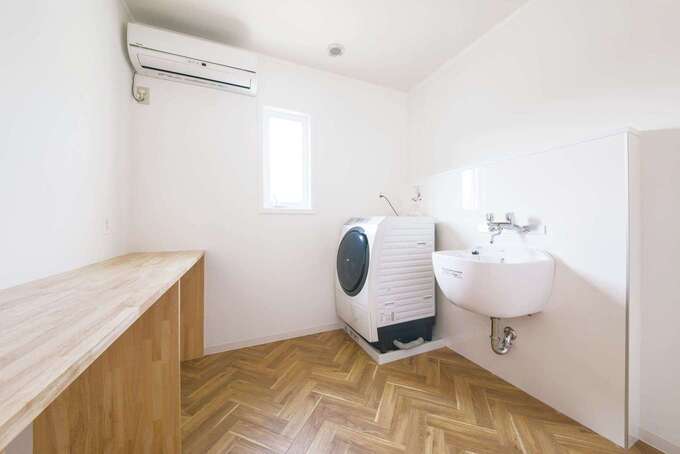 2階に設けたランドリールーム。靴洗い用シンク、部屋干し、アイロン台も備え、家事時間を短縮