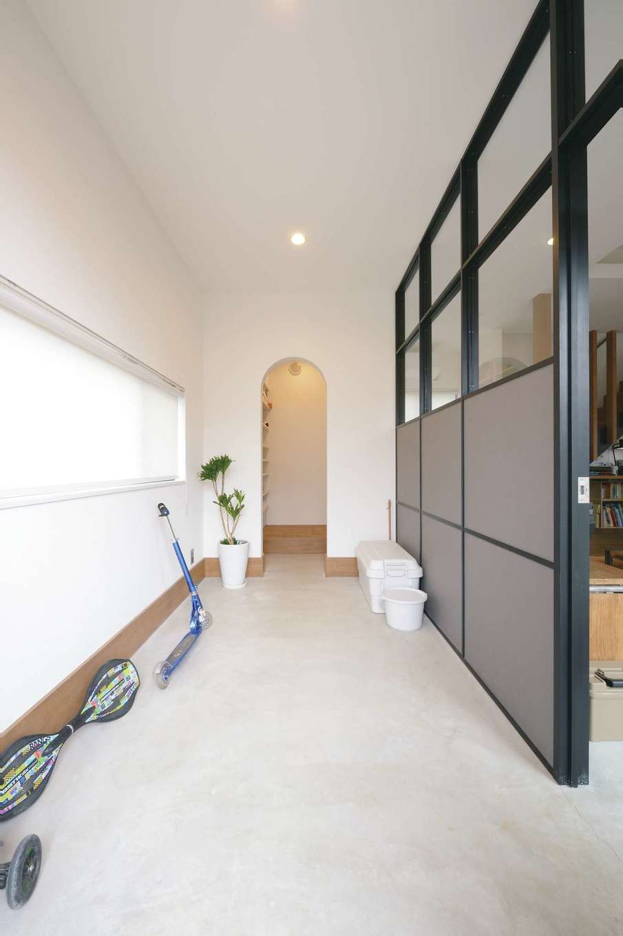 MABUCHI【デザイン住宅、狭小住宅、建築家】外国のアパルトマンを彷彿とさせる土間玄関。床はモルタル。間仕切りのフレームは木を黒く塗装してニュアンスを出した