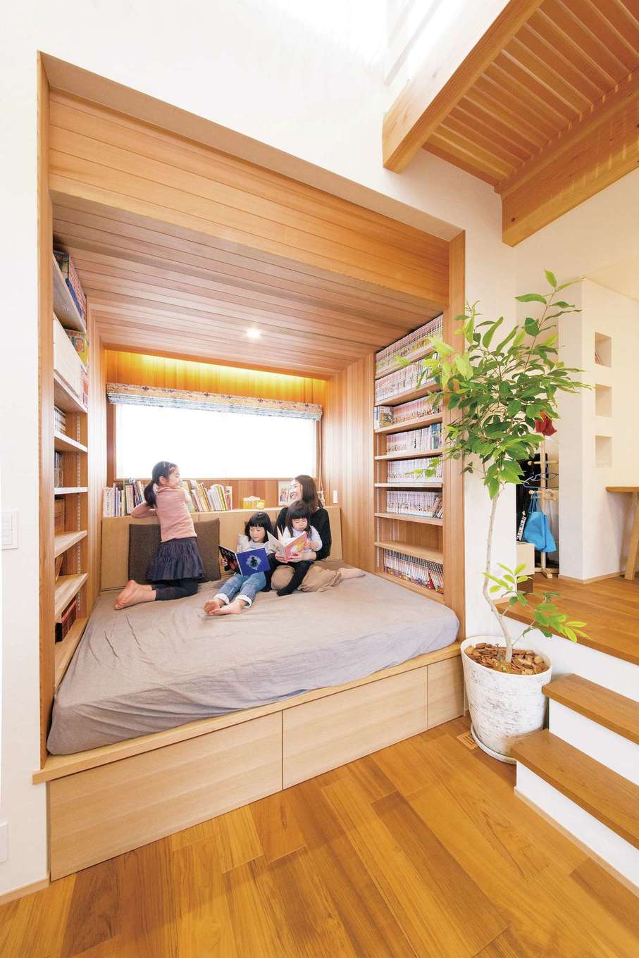 神谷綜合建設 カミヤの家【子育て、自然素材、スキップフロア】レッドシダーを使ったこもり感のあるライブラリーには、マンガのコレクションがずらり。背もたれの収納と引き出し式収納には、子どものおもちゃなどを片付けて、LDKもすっきり