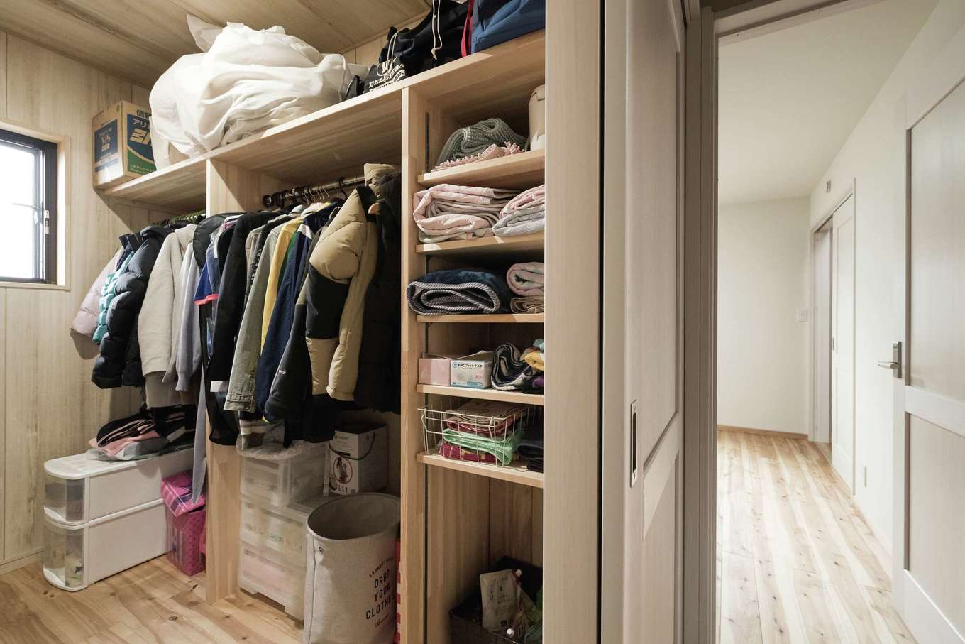 ワイズホーム【デザイン住宅、自然素材、省エネ】ウォークインクローゼットは夫婦の寝室からもホールからも出入りできる。家族の衣類を集約できるので、家事負担も軽減できる