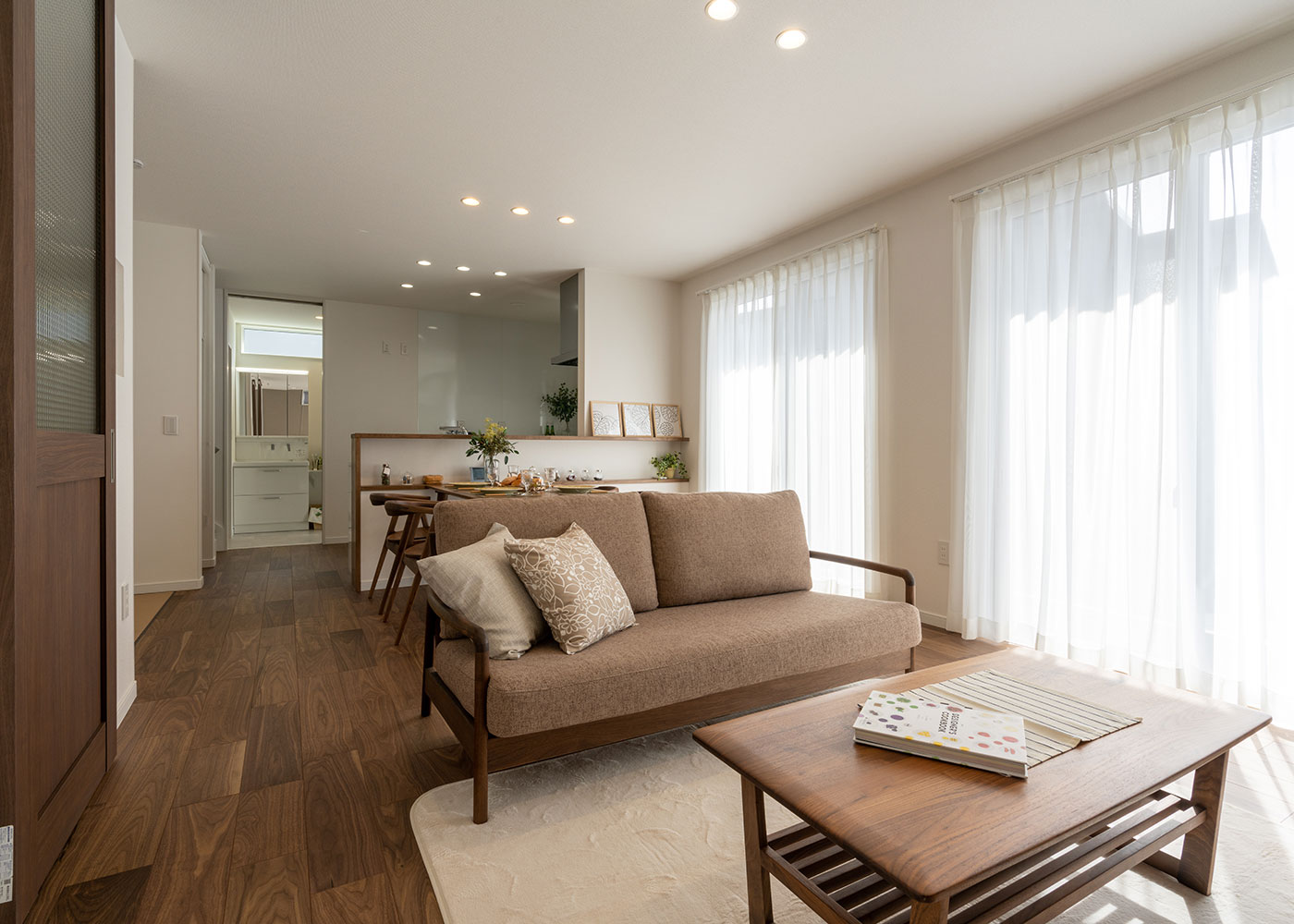 寺田工務店【収納力、省エネ、間取り】家族の集うLDKは、床、建具、家具をダークブラウンのウォルナットでまとめ、重厚で落ち着きのある空間に仕上げている