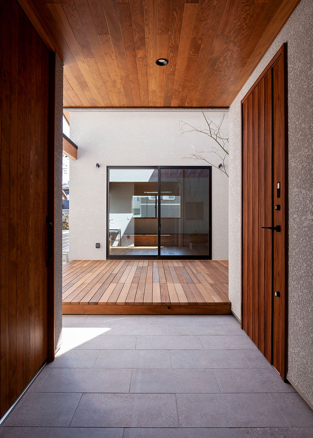 平成建設【デザイン住宅、子育て、間取り】大工が製作したエントランスの格子戸をあけると、中庭・リビングをまっすぐ見通せる、印象的なアプローチ