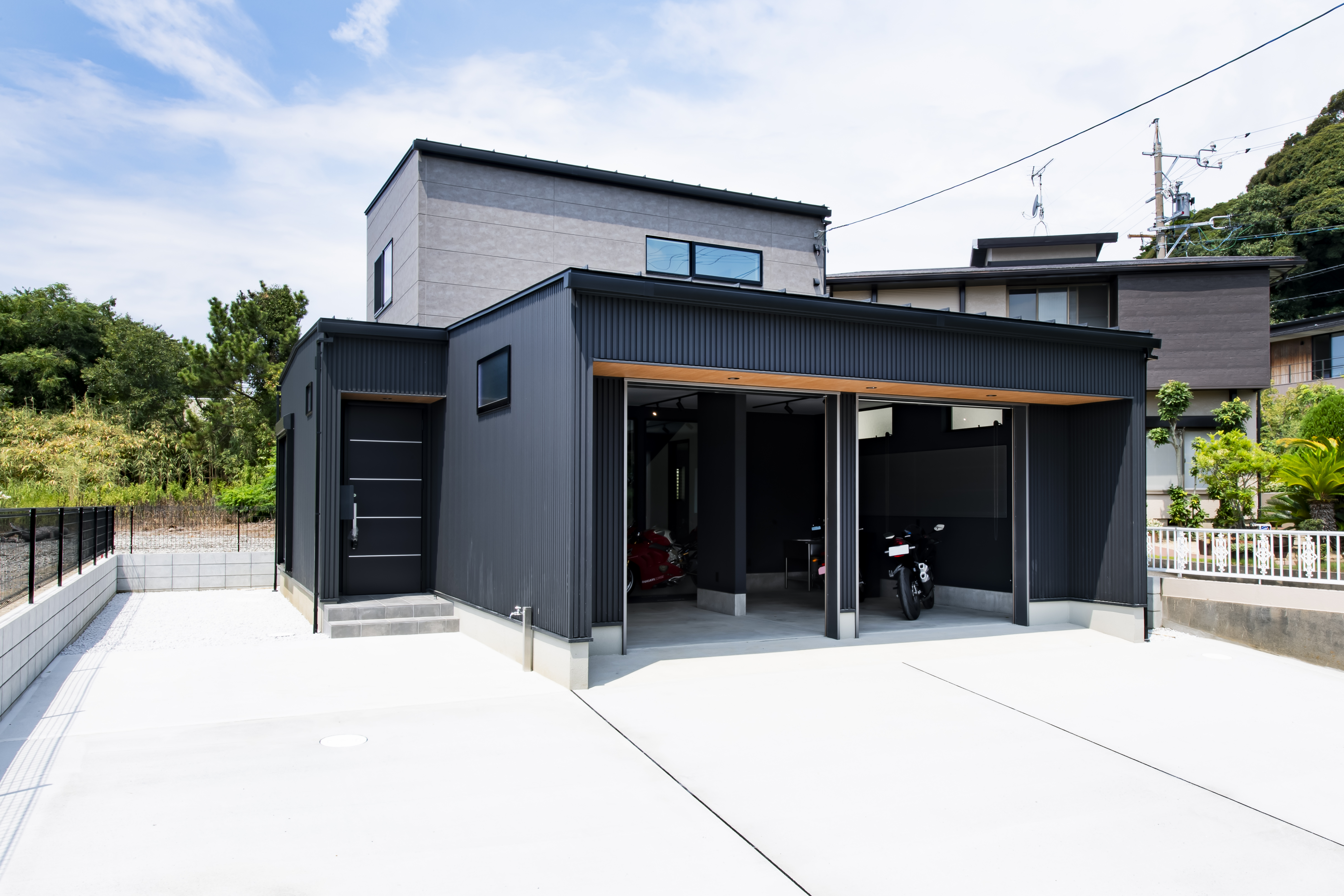 スズイチ｜スタイリッシュなデザインの住宅外観。ダークなカラーリングが洗練された印象を与え、ガレージも備えた利便性の高い設計。