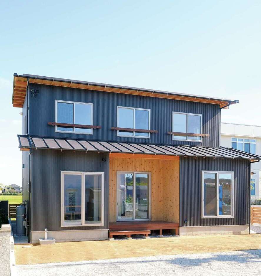 外壁はブラックガルバリウム、ウッドデッキ部分のみ米杉を採用。軒化粧した“見せる軒”が和を演出し、シンプルモダンながら味わい深い印象に