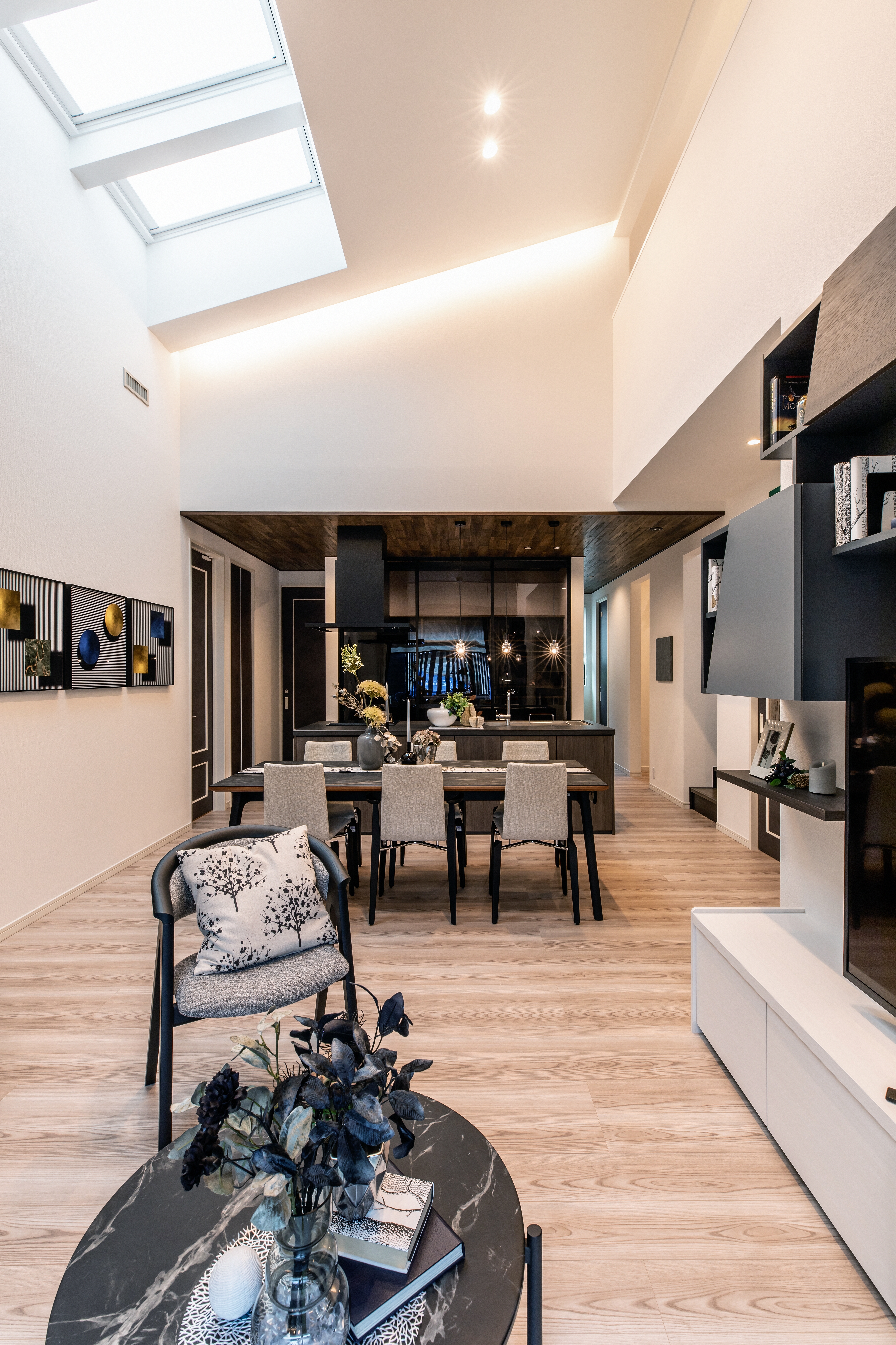 コンチネンタルホーム｜モダンなデザインのLDK。広々とした空間に高い天井と天窓からの自然光が差し込む。オープンプランのリビングとダイニングが一体化し、家族が集える心地よい空間を提供。