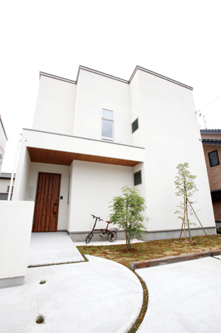 フォルムや塗り壁の表情は、同社が手がけた住まいを参考にした。通り側は開放部を減らし、南面を開いている