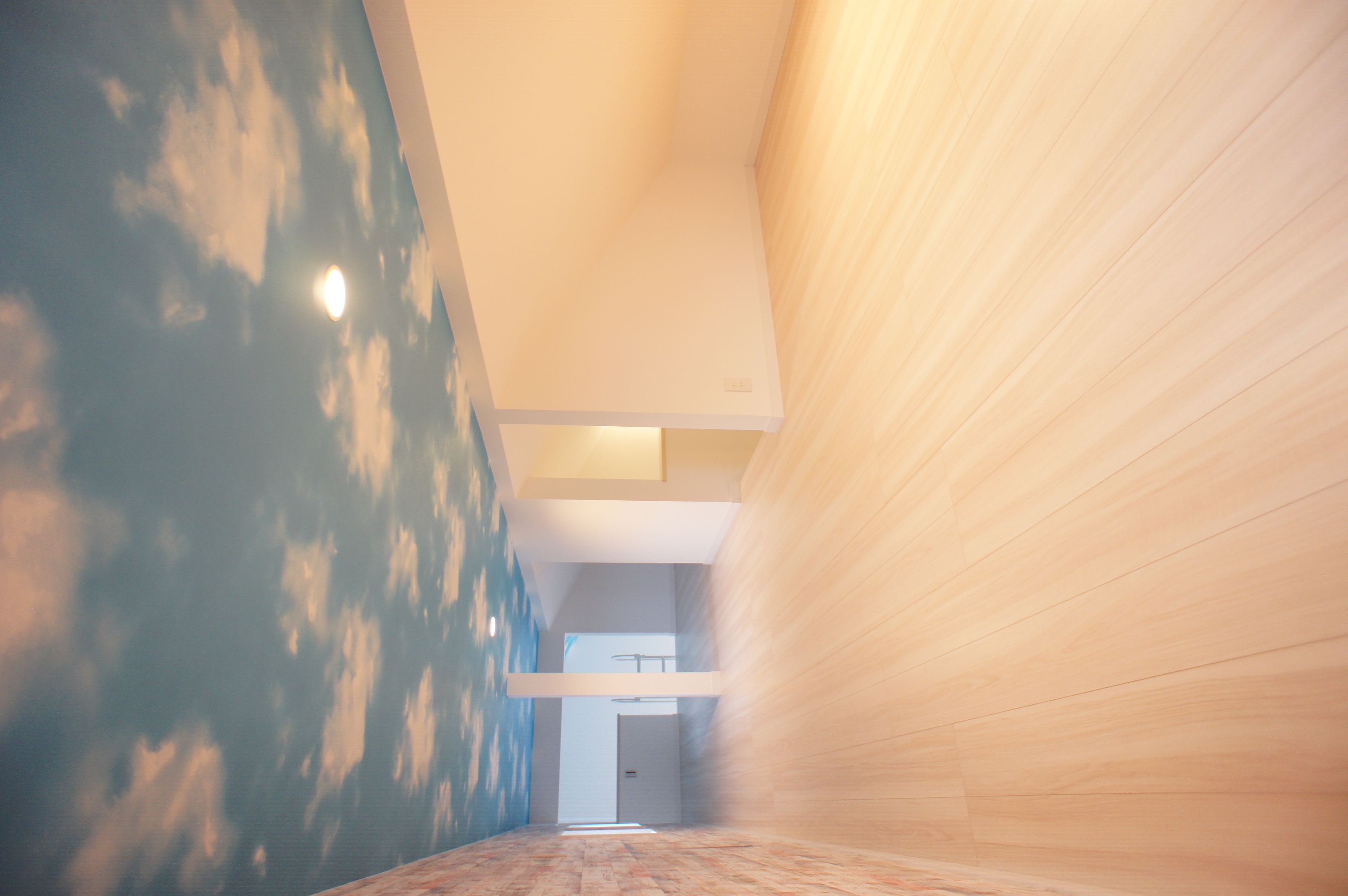 小野田産業～designers house project～｜青空が広がるような天井のデザインが特徴的な小屋裏収納。明るい木目の床と組み合わせ、自然光に満ちた快適な空間を演出しています。
