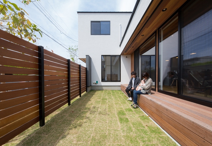 ウッドフェンスで目隠ししながら、BBQや子どもプールなどを楽しめる庭。深い軒が夏の直射日光を遮り、太陽高度の低い冬は、室内の奥まで光を届ける