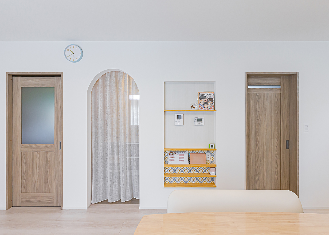 cozy house（小塚建設）【子育て、間取り、インテリア】LDKにかわいらしく並んだドアとニッチ。洗面室やランドリールーム、ご主人の書斎には直接アクセス。ニッチにはマグネットウォールを貼り、マガジンラックを造作した