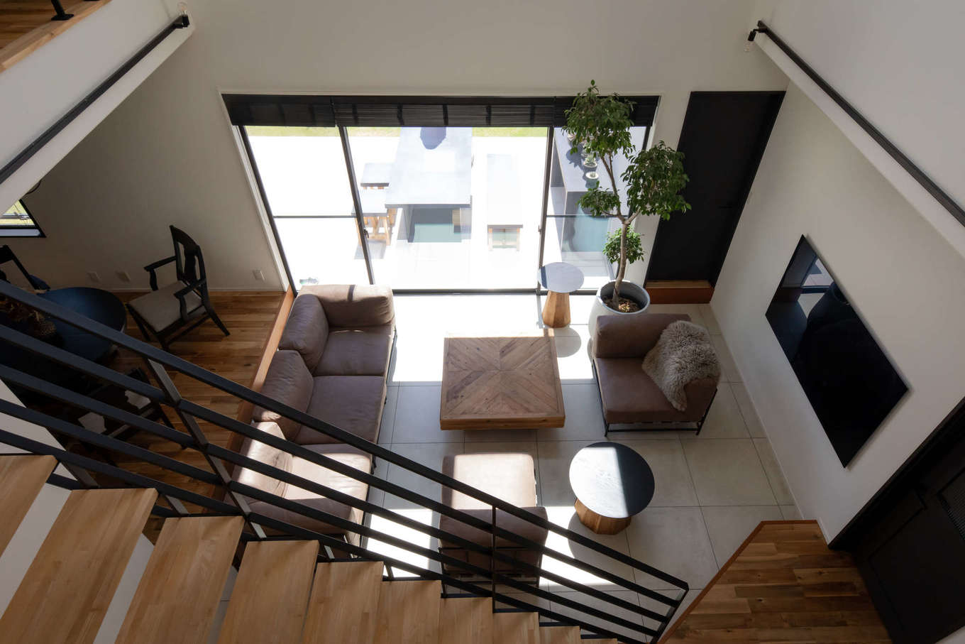 幸和ハウジング【デザイン住宅、夫婦で暮らす、ガレージ】２階から眺めたダウンリビング。窓の外にはテラスデッキが設けてあり、内と外の一体感が心地いい。SE構法によって、大空間・大開口を実現できた