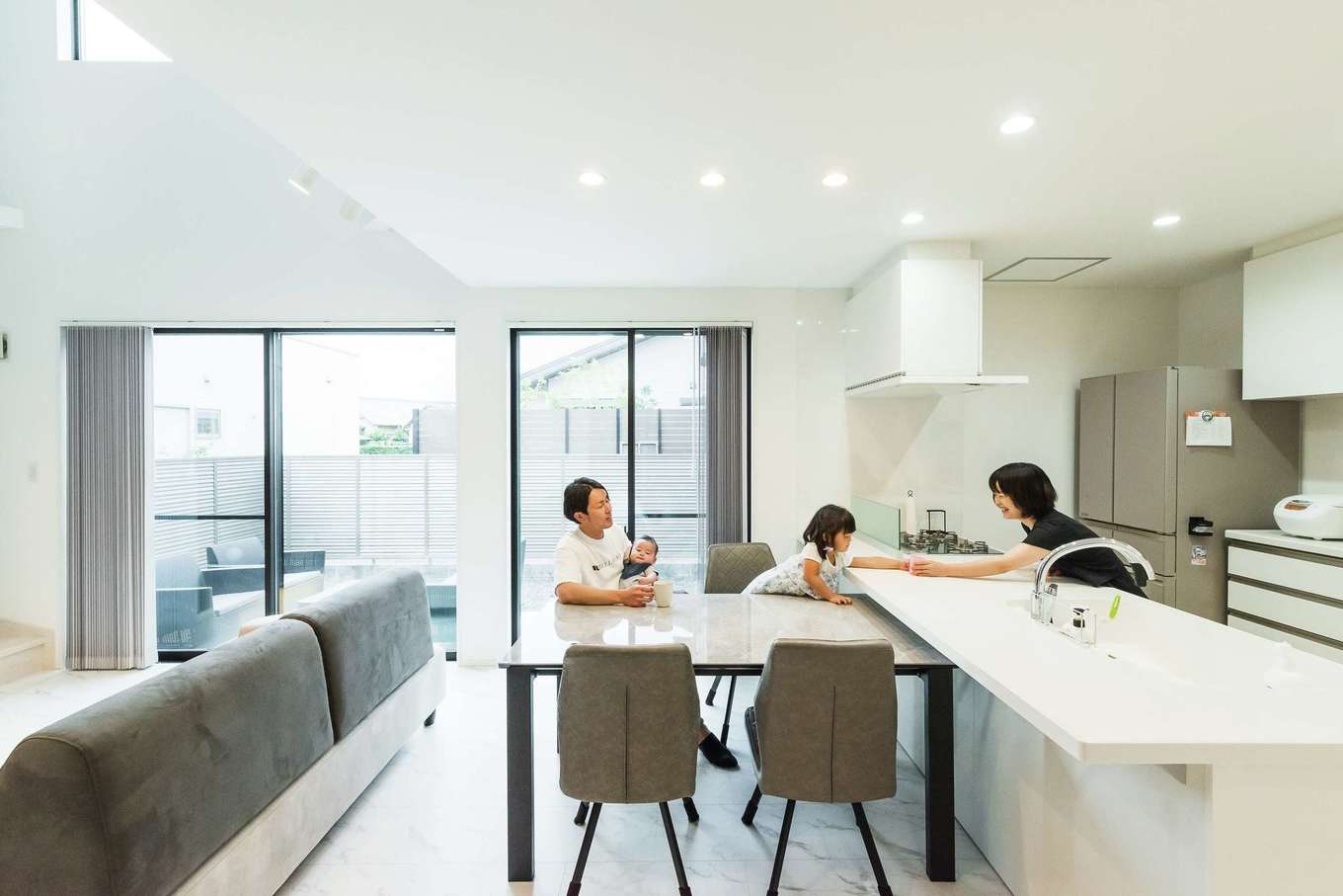 HAPPY HOUSE（山田工務店）【デザイン住宅、子育て、間取り】キッチンは奥さまの希望でコミュニケーションを取りやすい対面式のフラットタイプに。リビングの様子はもちろん、階段の上り下りや和室の気配まで届き、安心して見守ることができる。照明もレイアウトを考慮して計画されている