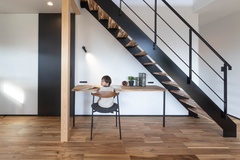 階段下に造作デスクを設け、お子さまのリビングでの勉強場所に。吹き抜けから落ちる光と、階段が創りだす陰影がクロスに映り、時間の流れを感じさせます。