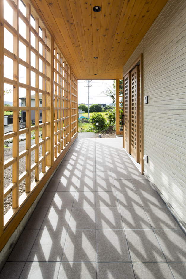一級建築士事務所 GO_AN (ゴアン)【デザイン住宅、和風、建築家】駐車場から玄関につながるアプローチ。屋根もついているので雨の日でも濡れずに移動できる。晴れた日は影も合わせて「格子の空間」に