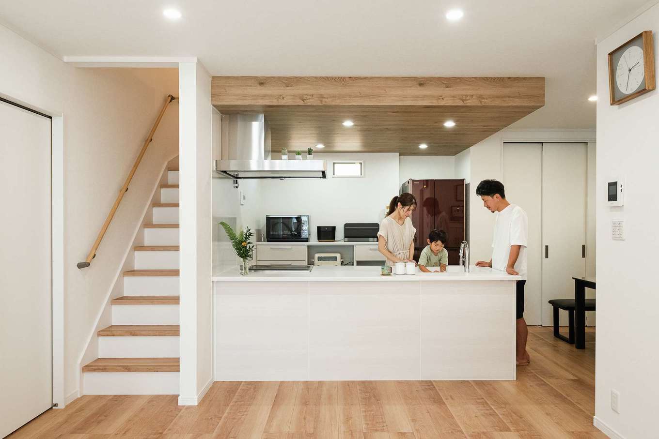 サンワ開発【デザイン住宅、収納力、間取り】憧れのオープンキッチンからはLDKを見渡せる。木調のクロスを張った下げ天井がアクセント