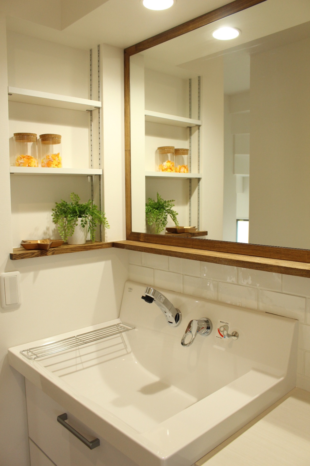 小野田産業～designers house project～｜大きな鏡とオープンシェルフが設置され、使い勝手が良い。木のアクセントが温かみを加えている。