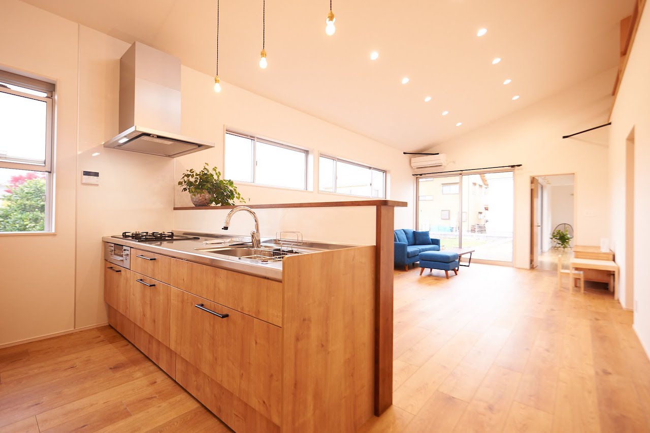 一級建築士事務所 GO_AN (ゴアン)【デザイン住宅、建築家、平屋】ステンレス天板のキッチンに、手元が隠せるよう高めのカウンターを造作で。部屋の奥に見える火打梁は構造上出てしまうが、黒く塗装したことでドライフラワーやエアプランツも映える