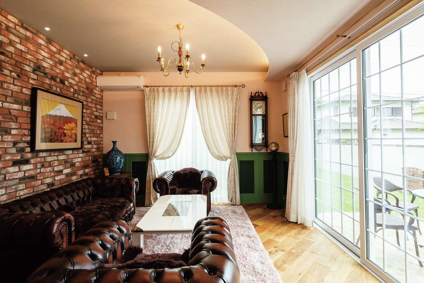 富士ホームズデザイン【デザイン住宅、自然素材、高級住宅】石張りのデッキに面した応接室。Rの天井と間接照明が空間の印象をやわらげる