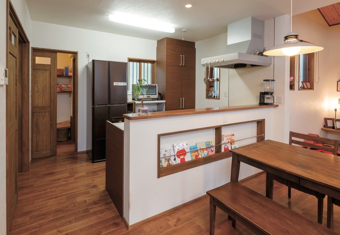 1階すべてが見渡せるオープンキッチン。パントリー、勝手口、サニタリーへの動線を短くして、奥さまの家事時間を短縮。マガジンラックは絵本のサイズに合わせて造作した