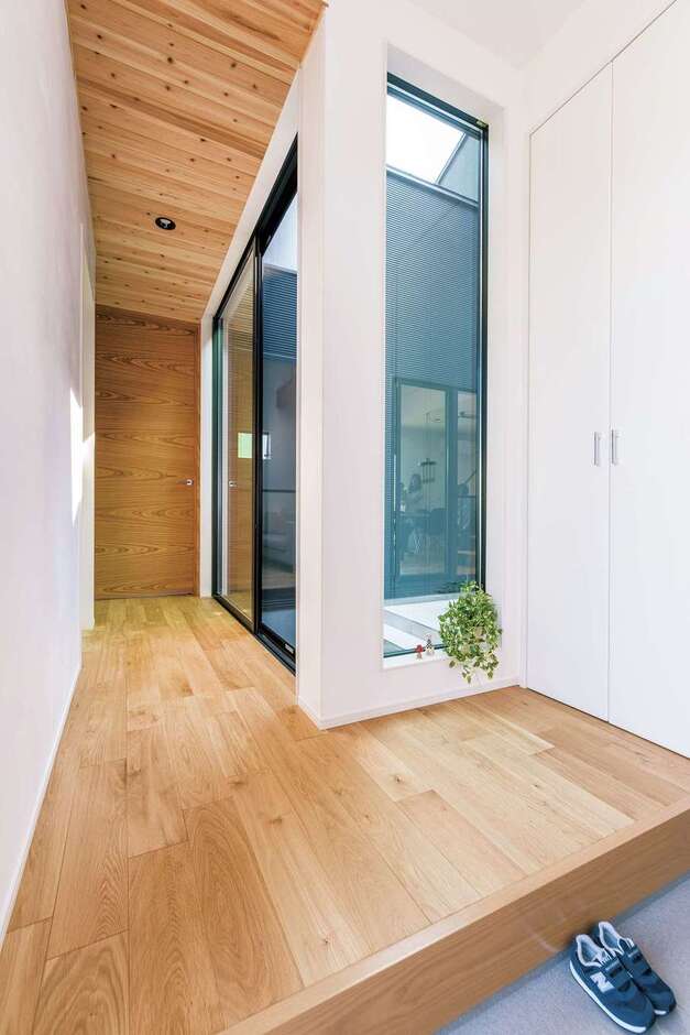 玄関から中庭が見えるホール。オリジナルハイドアと無垢の床、天井がベストマッチ