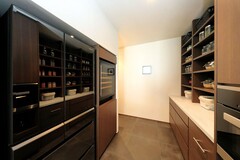 壁いっぱいに収納スペースが設けられたパントリー。調味料や食材が美しく整頓され、効率的な料理の準備をサポートする空間です。