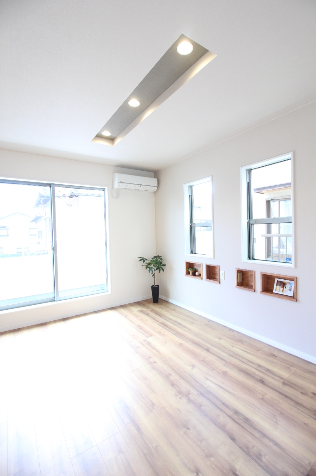 小野田産業～designers house project～｜明るい日差しが差し込むリビングスペース。シンプルな内装で、窓からの眺めを楽しみながらリラックスできる空間が広がる。