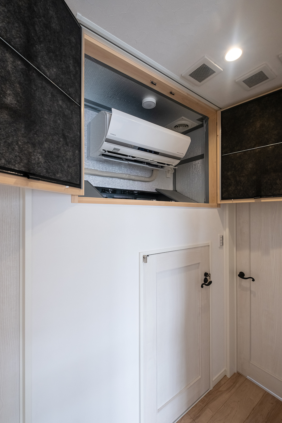 イデキョウホーム【子育て、収納力、省エネ】全館空調を支えるエアコン。夏は涼しく、冬はぽかぽかの快適空間を叶える。普段は目隠しされており、インテリアコーディネートの邪魔をしない