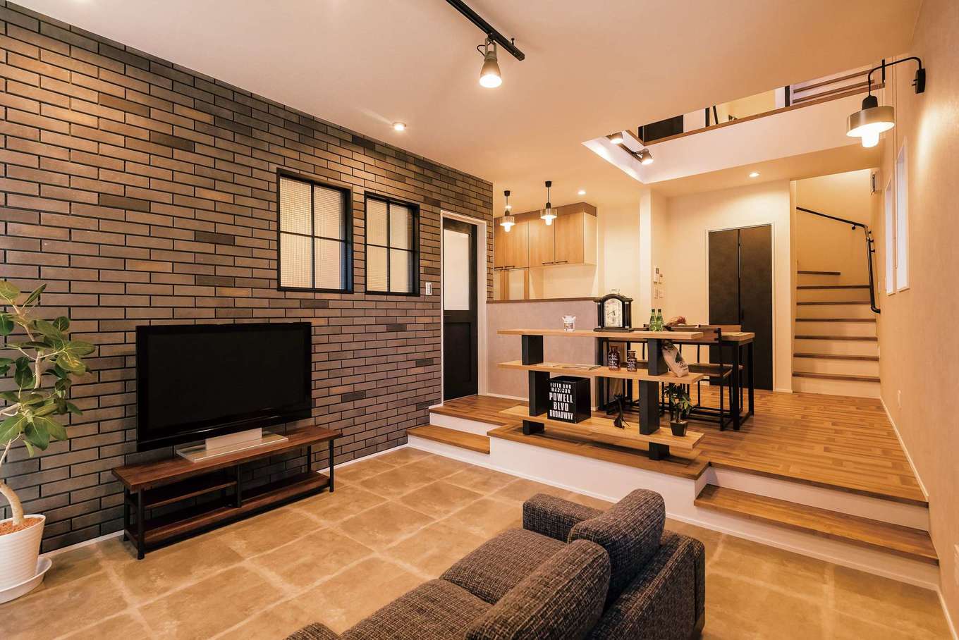 三和建設【省エネ、間取り、スキップフロア】リビングは床面を30cmほど下げることで、人が集まるスペースにメリハリをつけた。ステップ部分や窓辺のシェルフに腰掛けることもできる