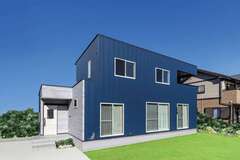 ガルバリウム鋼板の外壁をベースに、玄関ポーチのみ、光セラサイディングをアクセントに用いた外観。箱型のフォルムと鋼板の素材感が絶妙に調和して、クールな印象に仕上がった。同社自慢の高基礎が建物をしっかり支え、地震や水害などから大切な家族と住まいを守る