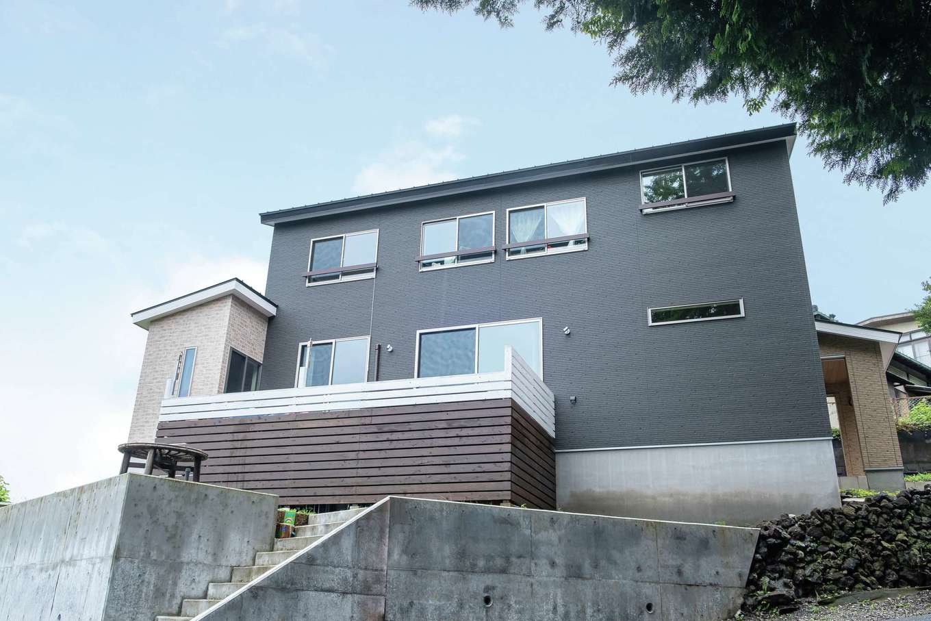 工藤建設【デザイン住宅、子育て、間取り】黒系メインのクールな外観。ウッドデッキの下は収納として活用する予定