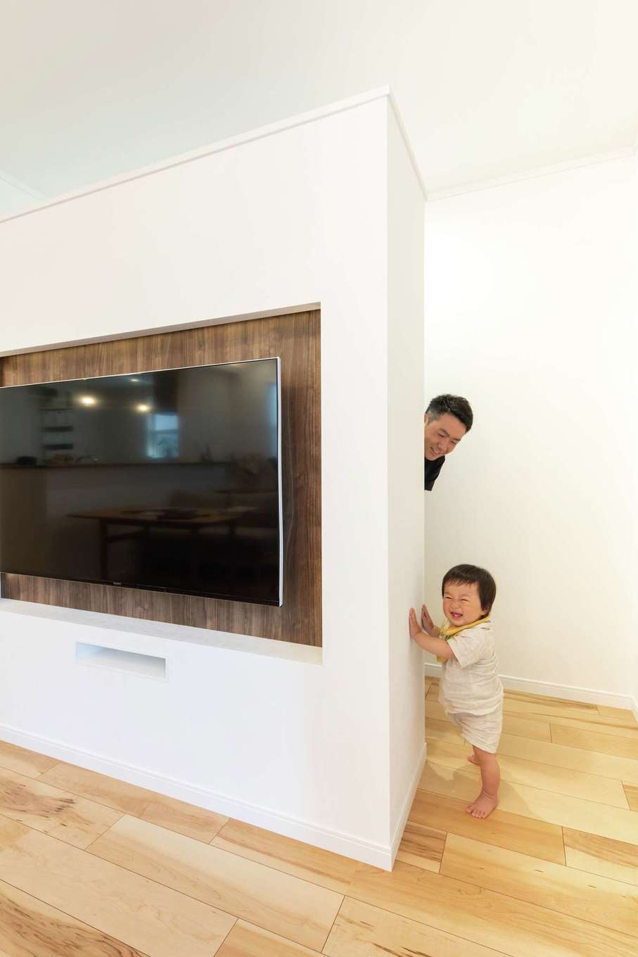 ハートホーム【デザイン住宅、子育て、間取り】テレビの背面に大容量の収納スペースを設けた。おもちゃや配線コード、ルンバなどを隠せるので、リビングはいつもスッキリ！