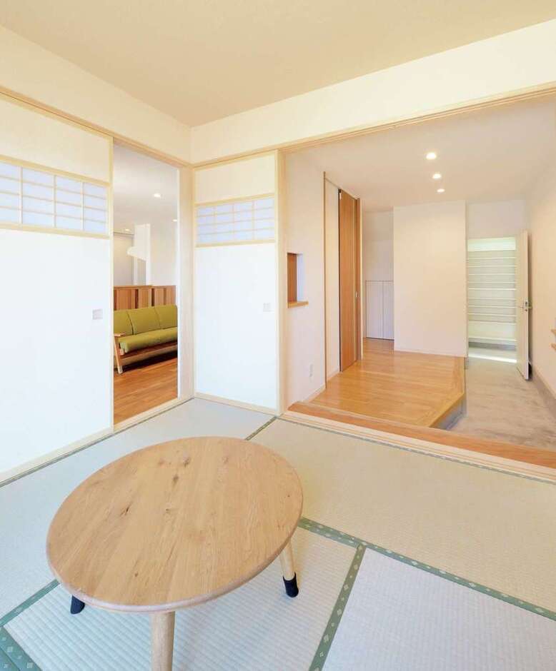玄関ホールとひと続きになる和室は、リビングともつながり回遊性のある間取りに。オリジナルで製作した、ヒバの建具も似合う