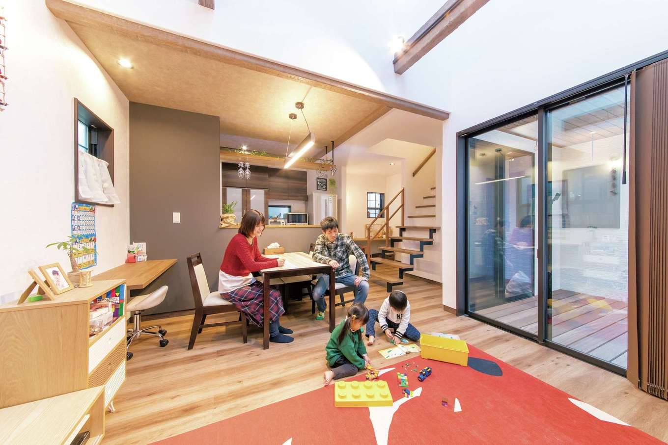 三和建設【子育て、収納力、自然素材】木の優しい質感に溢れたLDKは家族のお気に入り。キッチン上部の飾り棚にはグラスホルダーを取り付け、オリジナル空間にアレンジ。隣接のデッキではプール遊びも