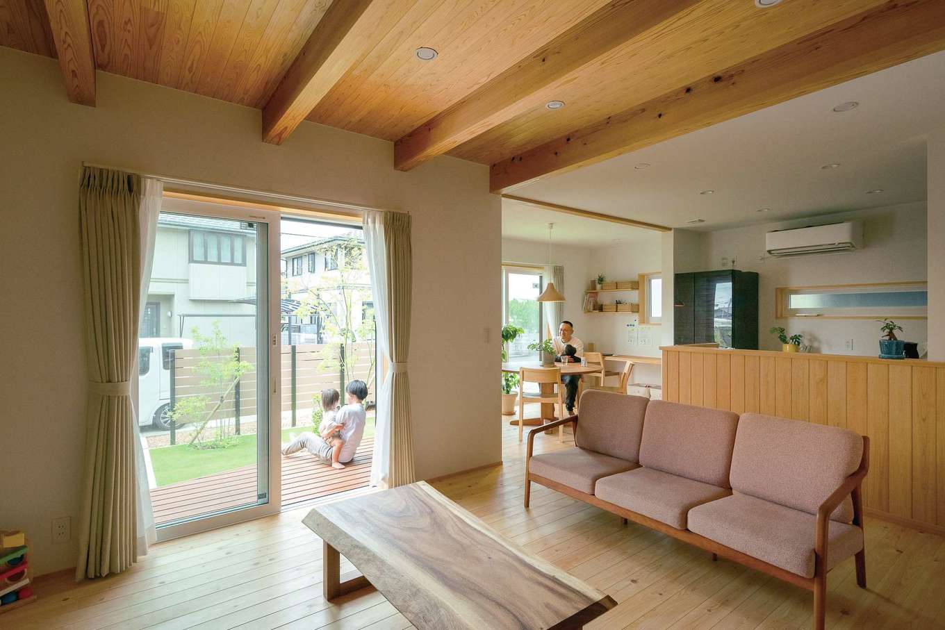 仲田工務店【子育て、自然素材、間取り】桧の無垢床に、杉張りの天井を合わせたリビング。壁は木目が明るく見える白をチョイス。掃き出し窓から庭に植えた木々の成長や芝生の緑を眺めるのも楽しみのひとつ