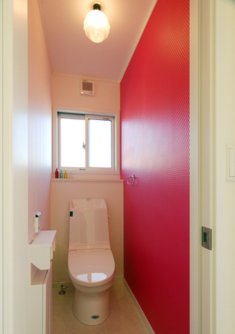 個性的な演出が楽しめるテクスチャーのクロスをアクセントに貼ったトイレ