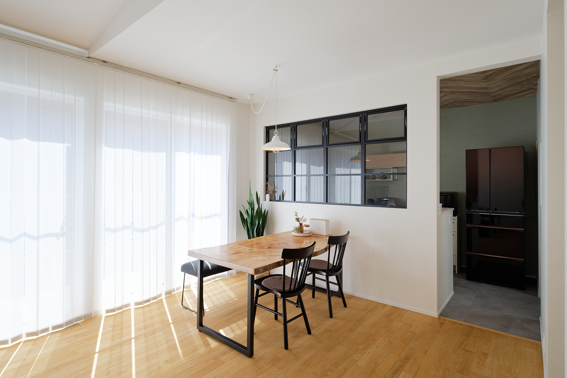 アサヒグローバルホーム｜リビング・ダイニングとキッチンを、アイアンのおしゃれな室内窓で緩やかにゾーニング。Iさんがイメージしていた通り、独立した一部屋のような感覚でキッチンを使うことができるものの、お互いに相手がいま何をしているかが見えて安心感がある