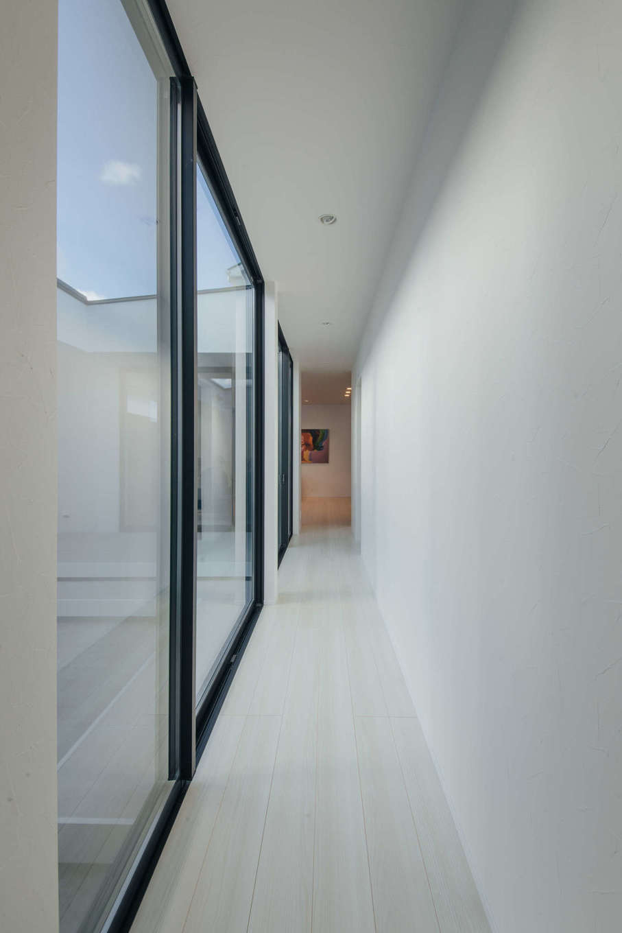 ハウスコネクト【デザイン住宅、ペット、平屋】玄関からLDKへと中庭を眺めながら進む長い廊下が、視線の先に広がる空間への期待感を高めている